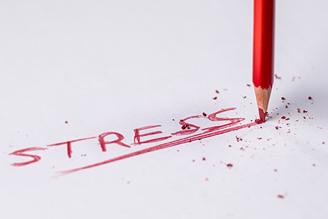 Red "Stress" written on white paper, with broken pencil in top right corner