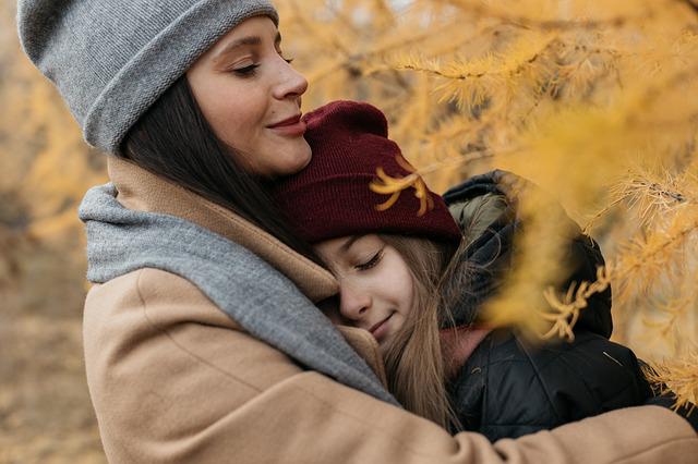 Mother comforting her daughter in an autumn scene.